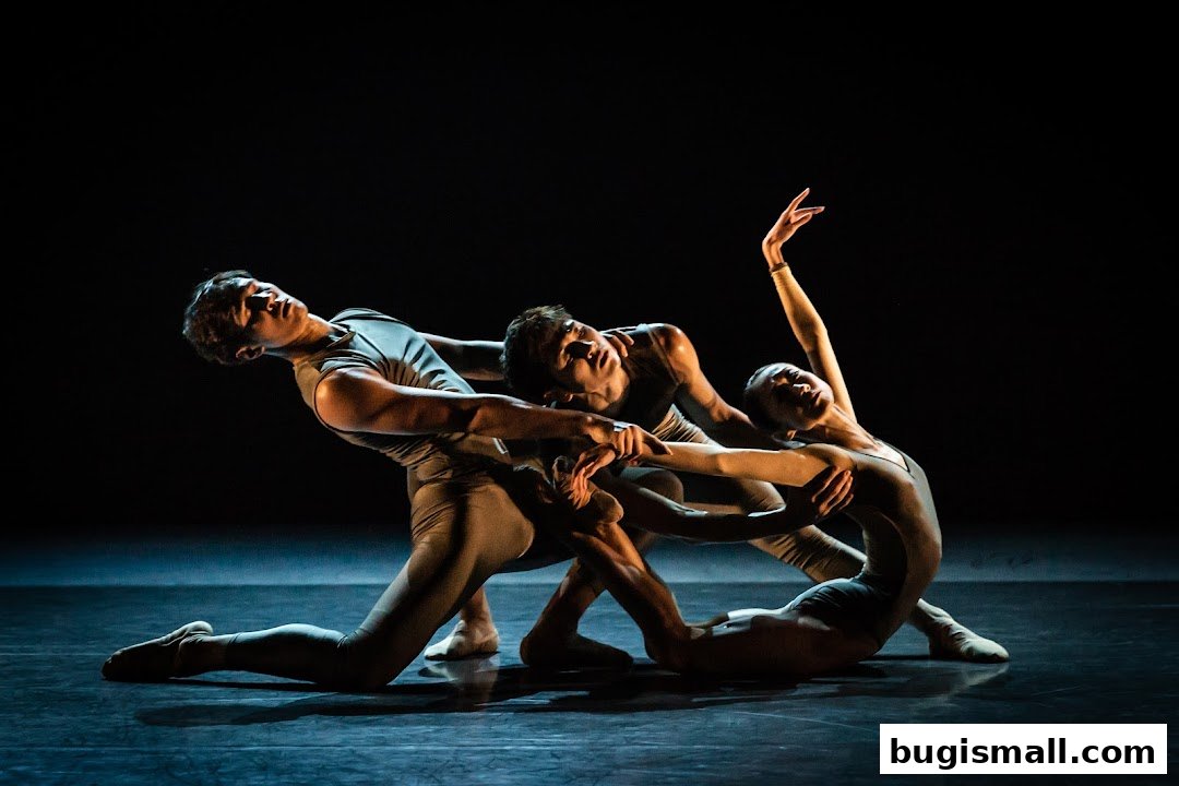 Three dancers in muted leotards perform a synchronized ballet routine on a dark stage.