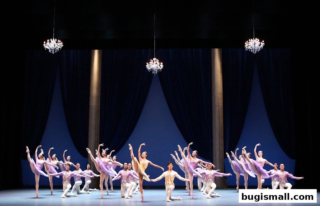 A ballet company performs on stage with elegant costumes and chandeliers.