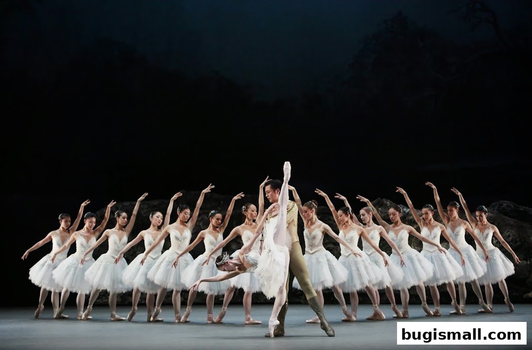 A ballet performance with dancers in white tutus and a male dancer in gold.