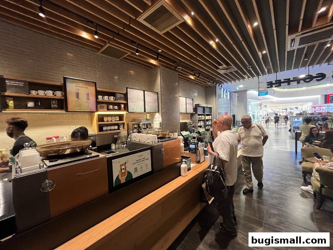 Interior view of a Starbucks cafe with customers at the counter and seating area.