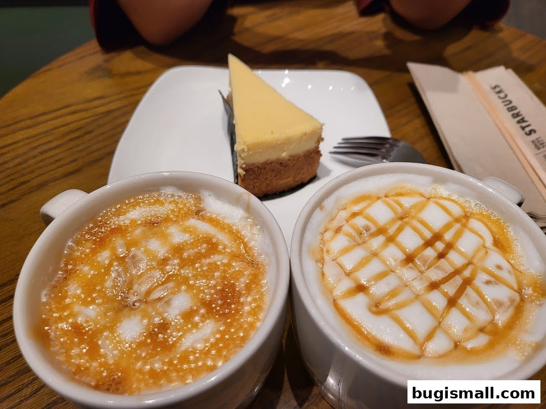 Two caramel macchiatos and a slice of cheesecake served on a table.