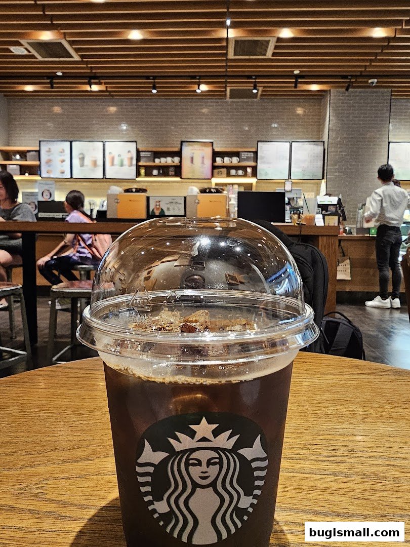 A close-up of an iced coffee at Starbucks with the store interior in the background.