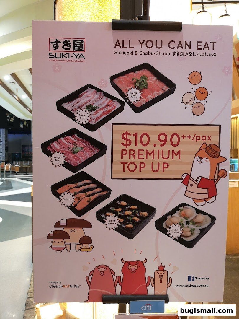 A promotional poster for Suki-Ya's all-you-can-eat Sukiyaki & Shabu-Shabu with premium top-up options.