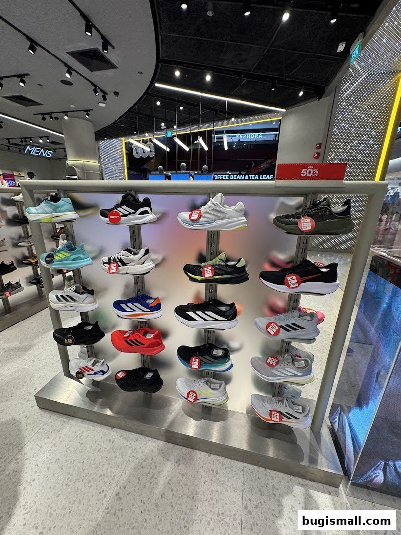 A display of various athletic shoes for men and women on shelves in a retail store.