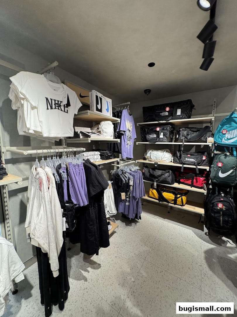 Interior view of a sports apparel store showcasing Nike and other branded clothing and bags.