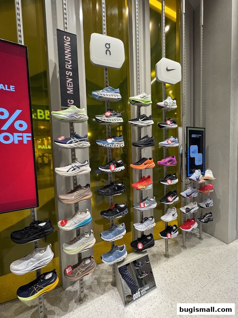 A display of various running shoes from different brands on shelves.