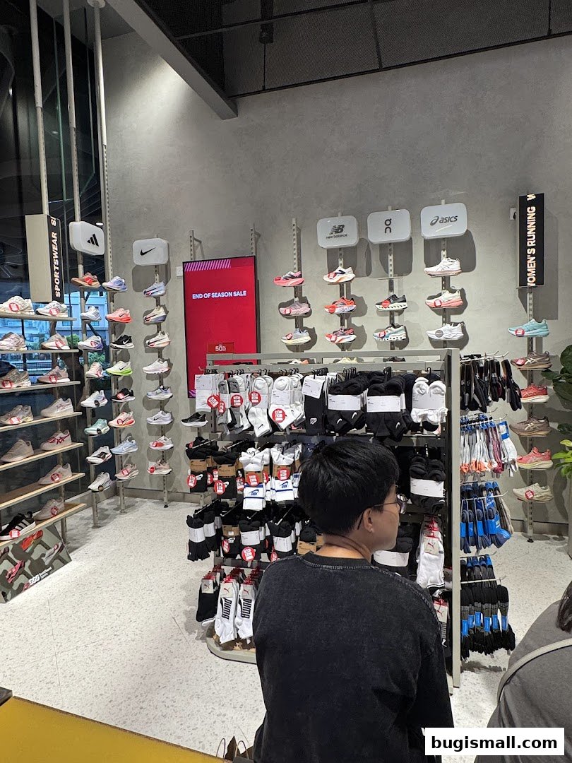 Interior of a sports apparel store showcasing shoes and socks with an end-of-season sale sign.