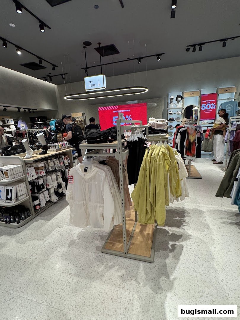 Interior view of a Sun Sand Sports store with clothing racks and a 'Pay Here' sign.