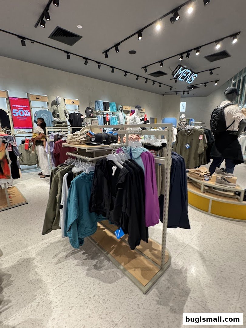 Interior of a sports apparel store with clothing racks and mannequins.