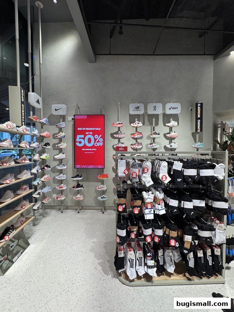 Interior view of a sports apparel store showcasing shoes and socks with a sale display.