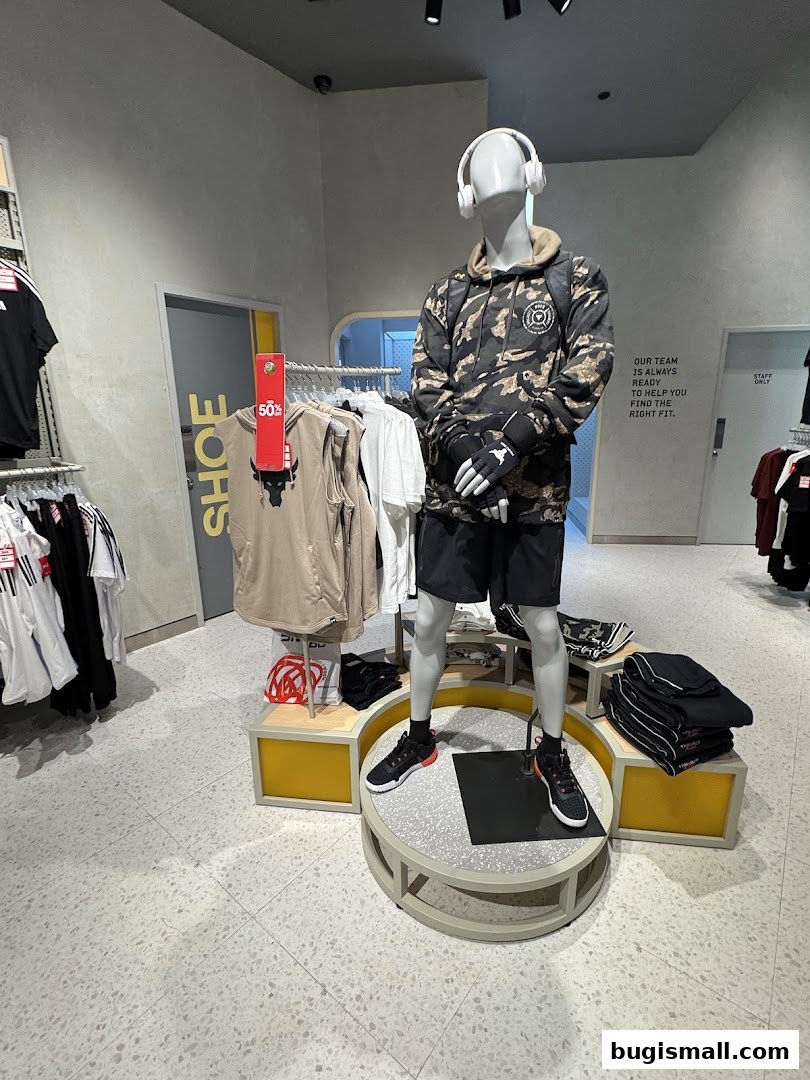 Mannequin dressed in athletic wear with headphones and sportswear displayed in a store.