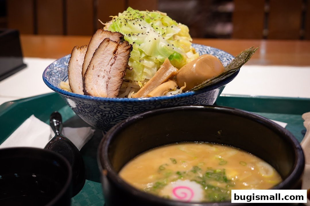 A close-up of a delicious bowl of ramen with chashu pork, egg, and vegetables.