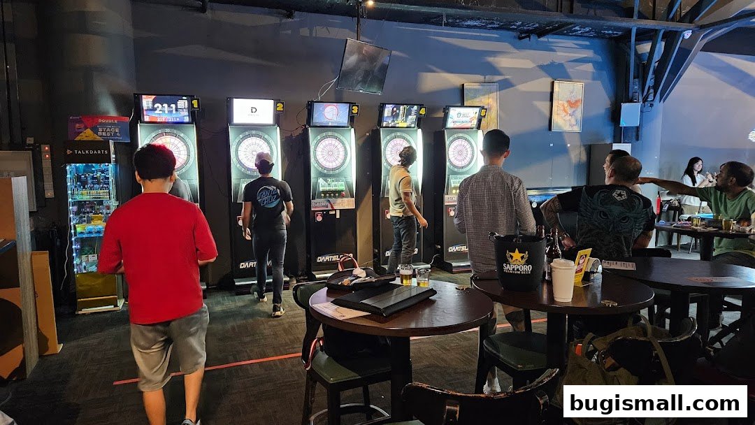 People playing darts at an indoor entertainment venue with multiple dart machines.