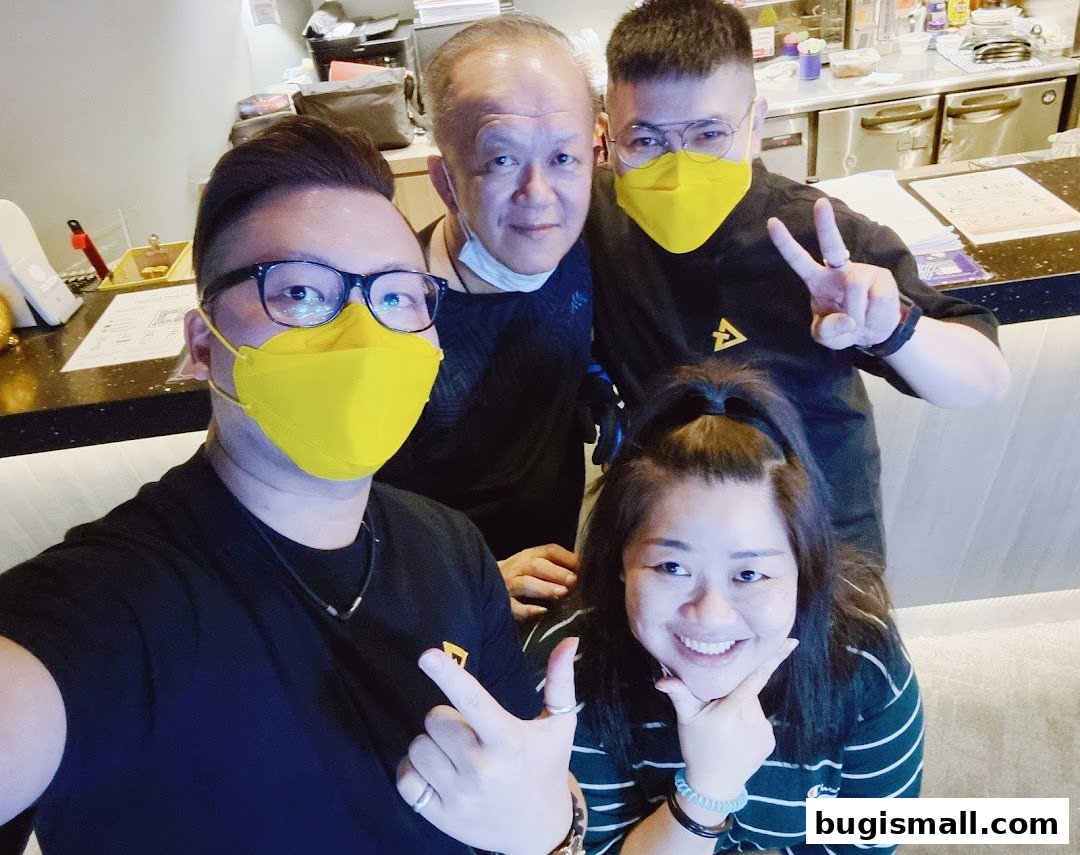 Four people wearing masks pose for a selfie in what appears to be a bar or restaurant.