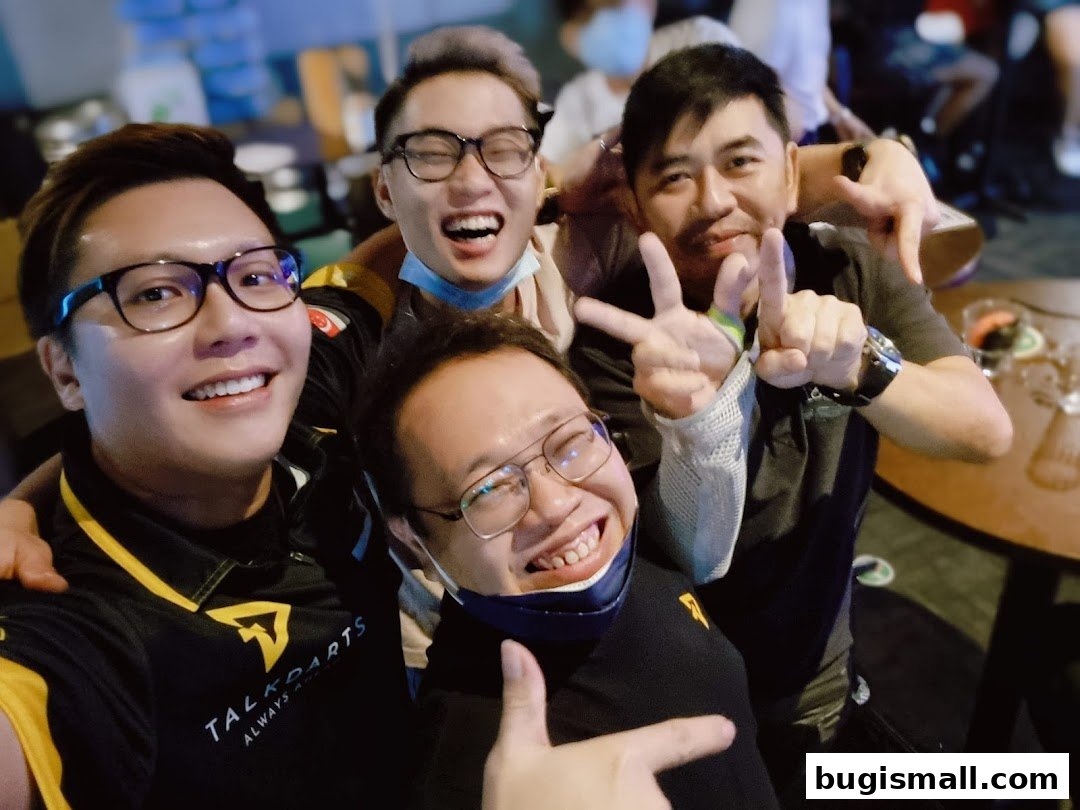 A group of four men smiling and posing for a photo, some making peace signs.