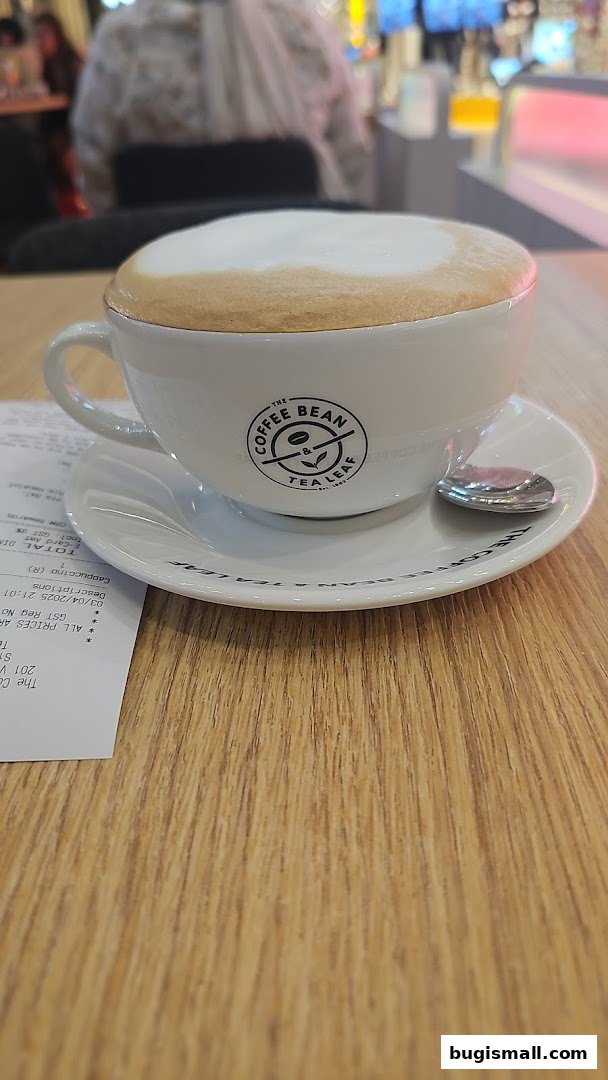 A close-up of a cappuccino with The Coffee Bean & Tea Leaf logo on the cup.