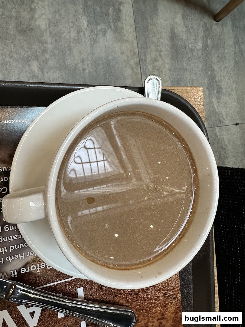 A close-up shot of a steaming cup of hot chocolate on a saucer with a spoon.