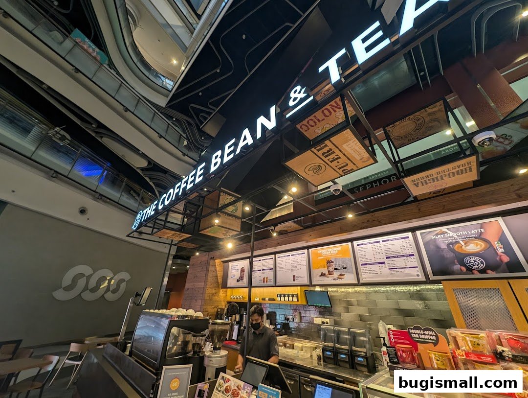 Interior view of The Coffee Bean & Tea Leaf shop with a barista and menu boards.