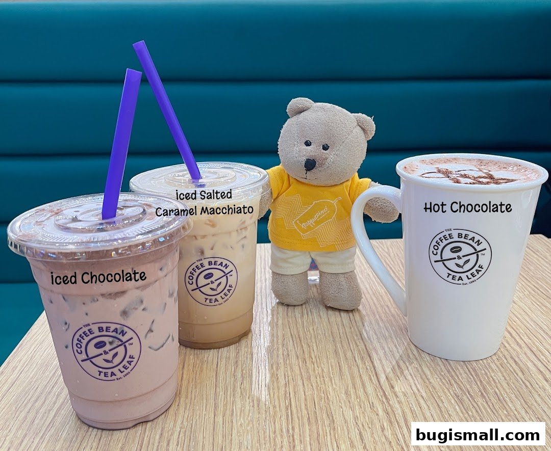 A teddy bear sits with three drinks from The Coffee Bean & Tea Leaf.