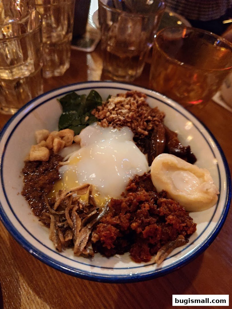 A close-up of a delicious bowl of food with a poached egg and various toppings.