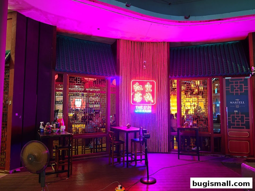 The Inn Livehouse Bugis features a vibrant neon sign and traditional Asian-inspired decor.