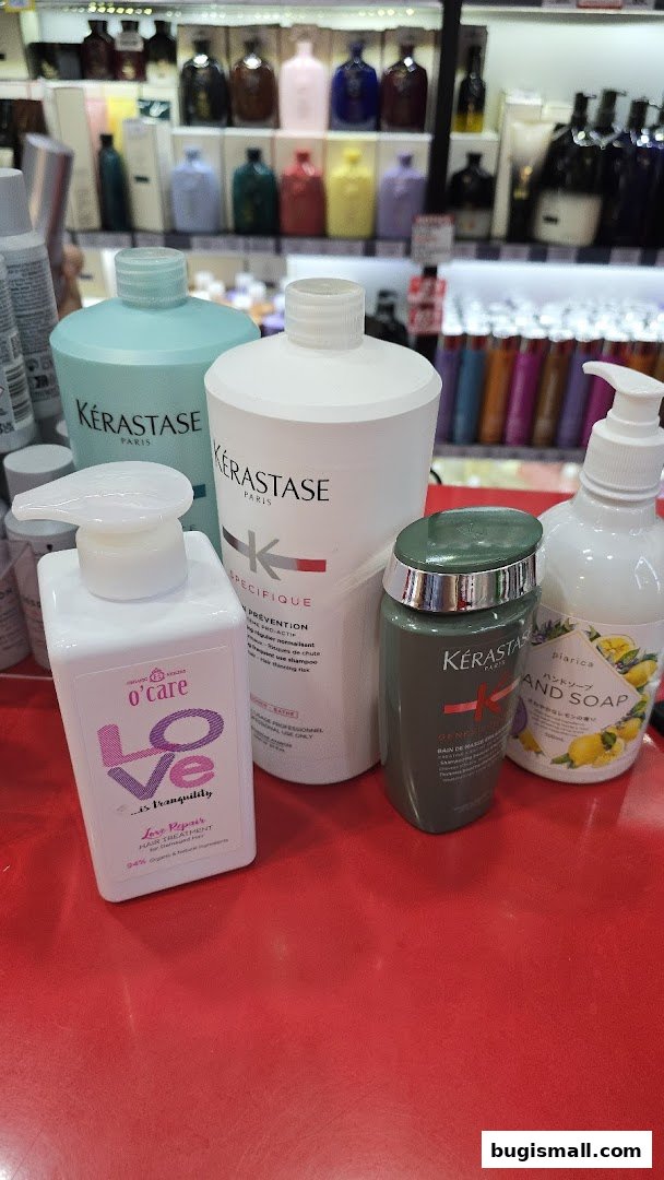 A collection of Kérastase hair care products and a hand soap on a red surface.