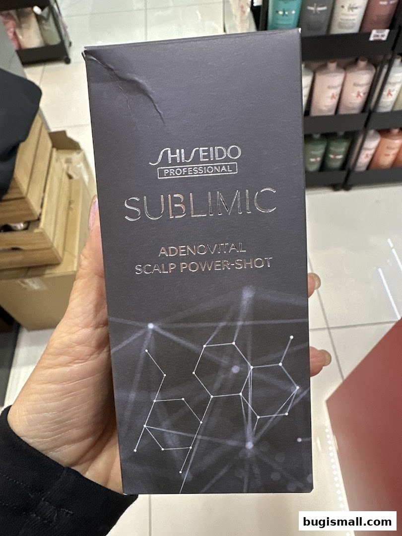A hand holds a Shiseido Professional hair product box with a molecular design.