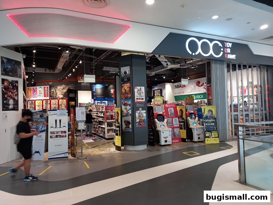 The entrance of a brightly lit toy and game store with displays of video games and consoles.