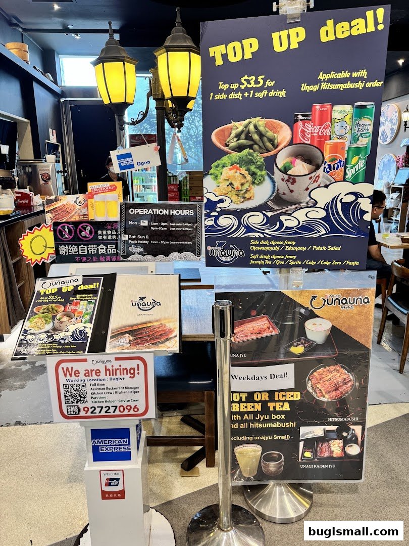 A restaurant display with promotional signs for food and drinks, and a hiring notice.