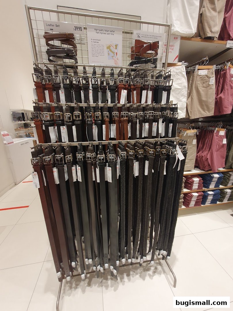 A display of various leather belts in different colors and styles at UNIQLO.