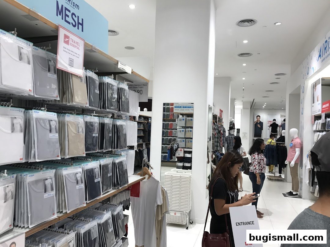 Interior view of a Uniqlo store showcasing AIRism Mesh clothing and an entrance sign.
