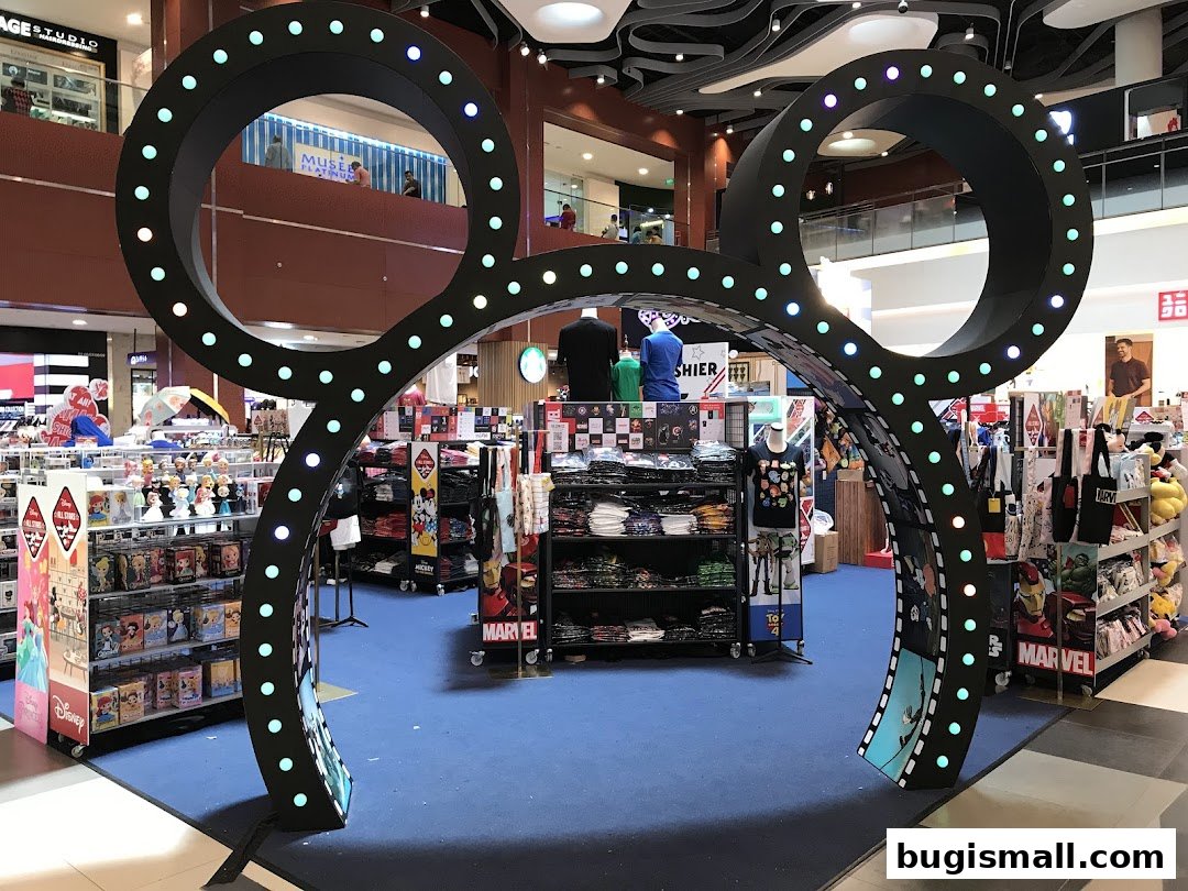 A Disney-themed archway leads into a retail store selling apparel and merchandise.