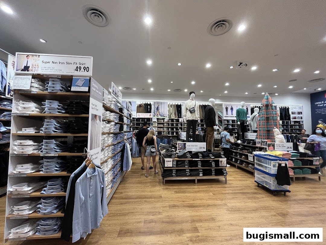 Interior view of a UNIQLO store showcasing folded shirts and mannequins displaying outfits.