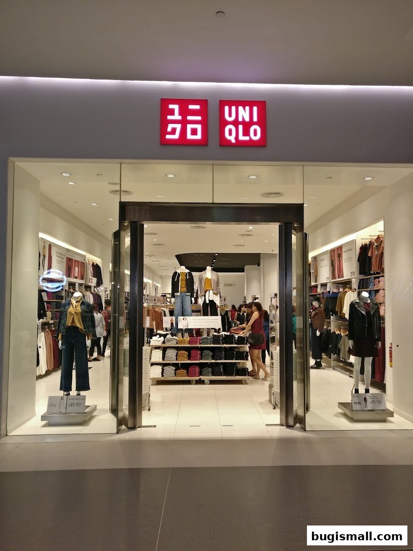 The entrance of a UNIQLO store showcasing mannequins and folded clothing displays.