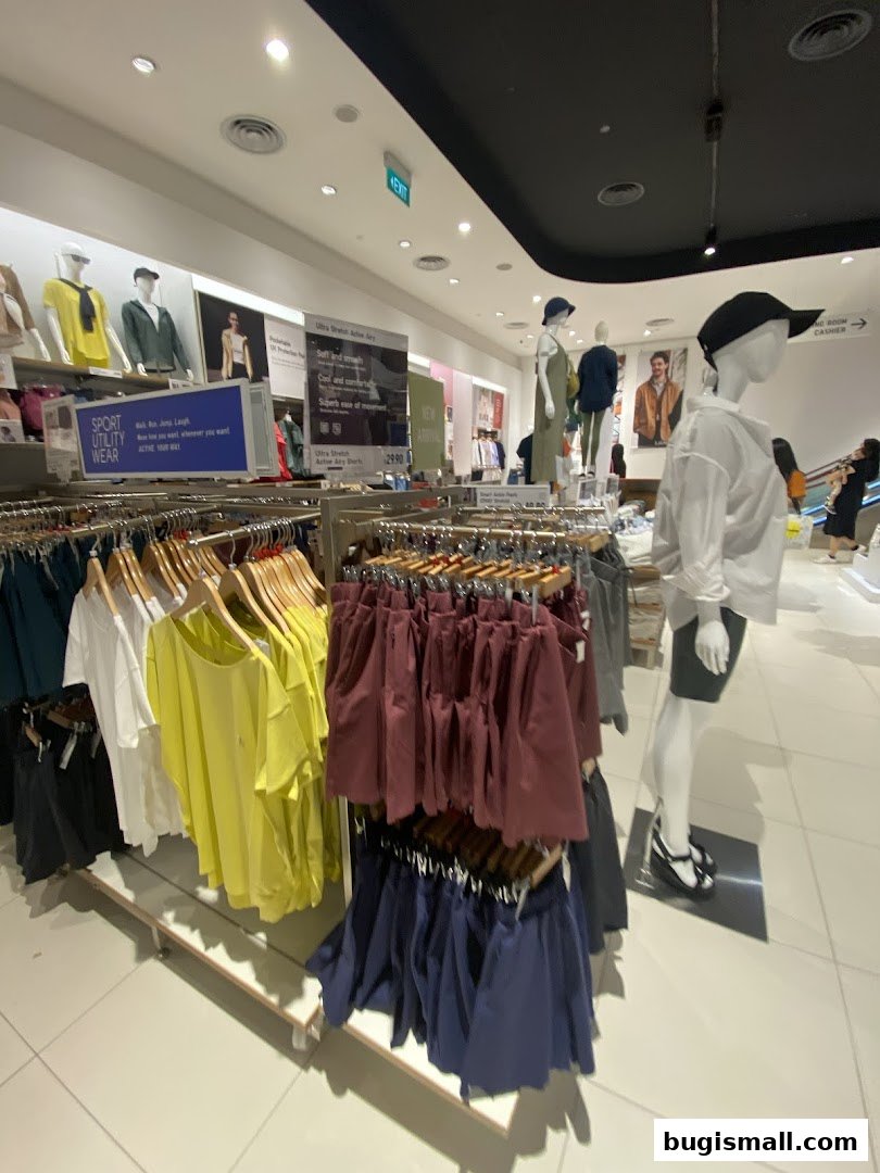 Interior view of a UNIQLO store showcasing sportswear and casual wear on display racks and mannequins.
