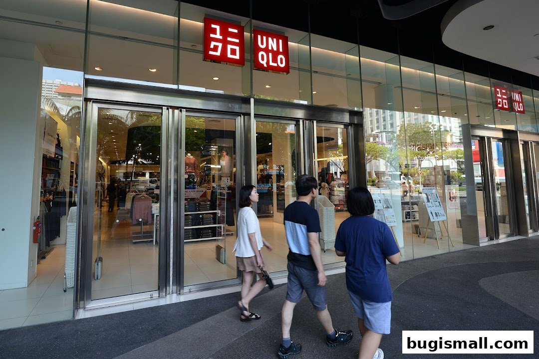 The exterior of a UNIQLO store with large glass windows and automatic doors.