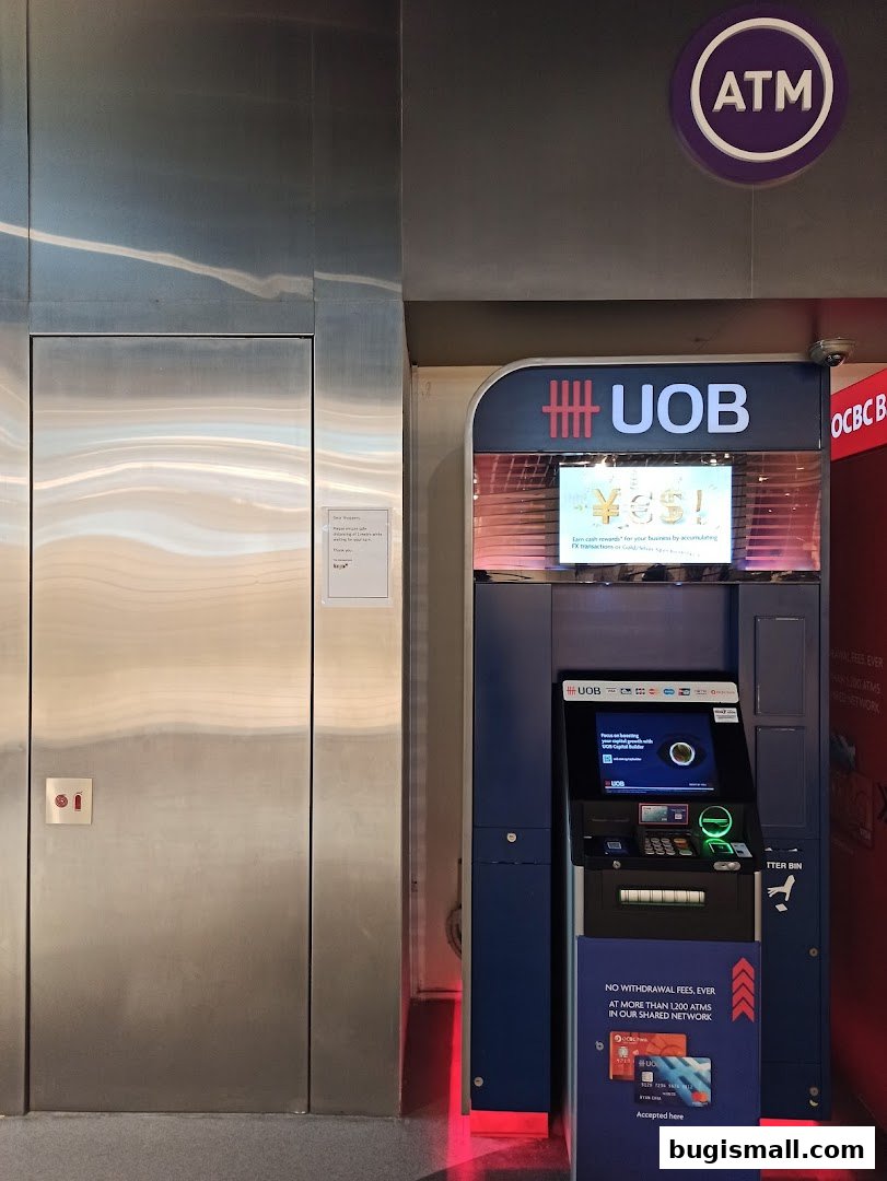 A UOB ATM machine is shown next to a metallic door with an ATM sign above.