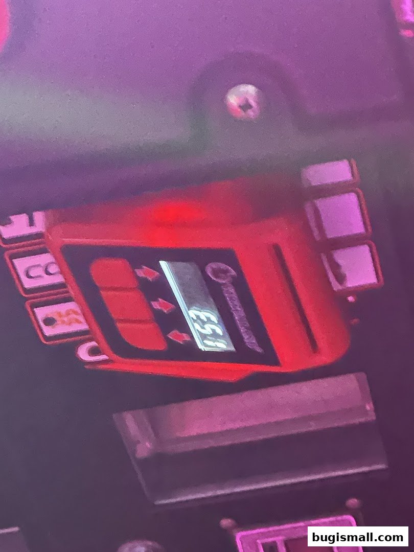 Close-up of a red electronic device with a digital display showing '1:53'.