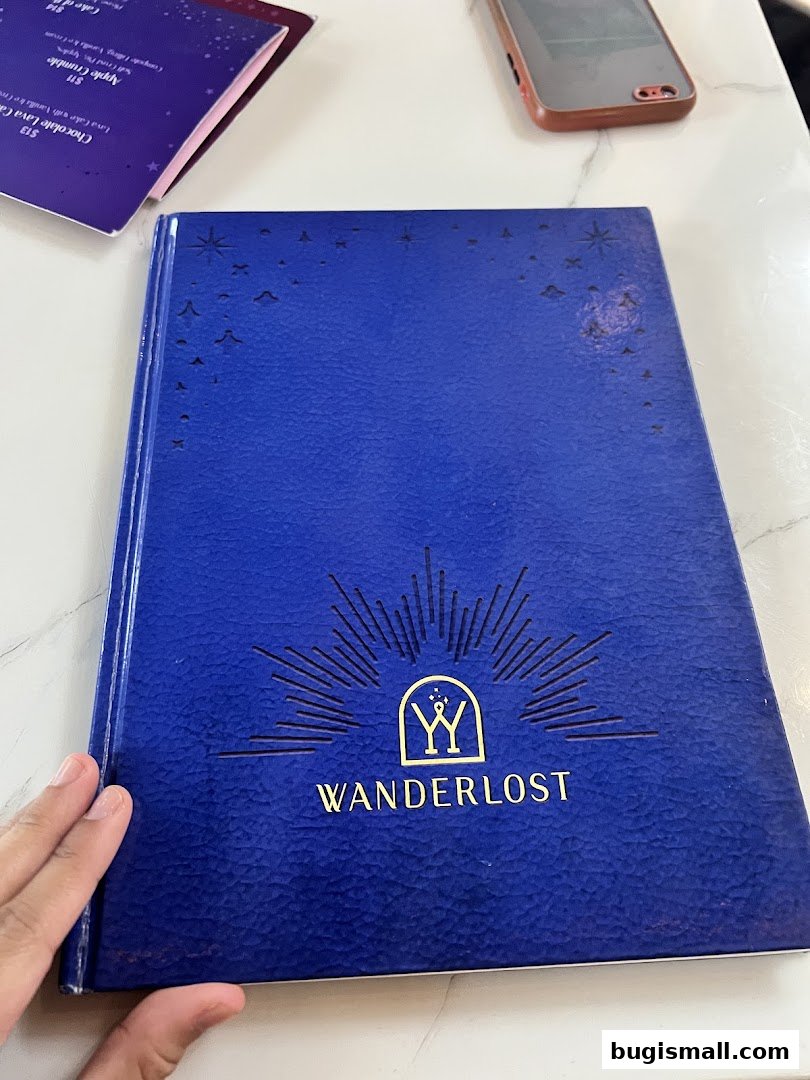 A blue menu book with gold lettering and stars, next to a phone.