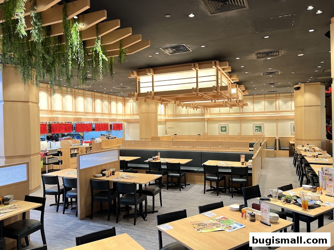 Interior view of a Japanese dining restaurant with wooden tables and chairs, and hanging plants.