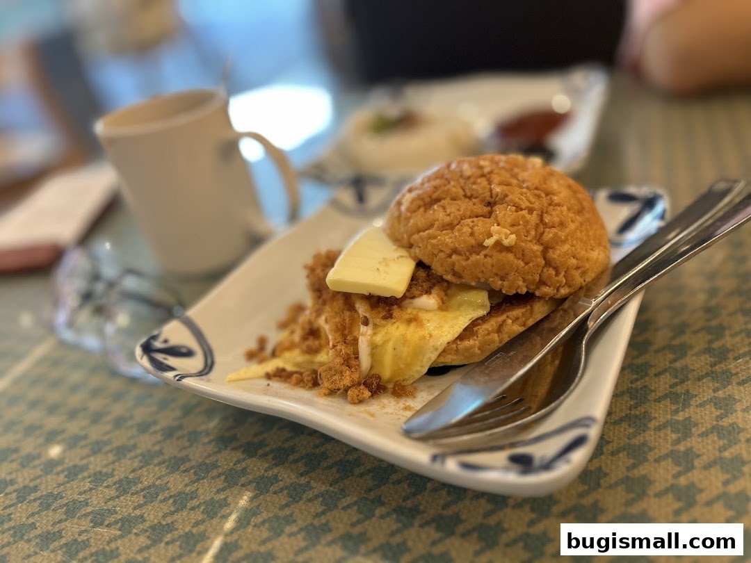 A close-up of a Hong Kong-style pineapple bun with butter and scrambled eggs.