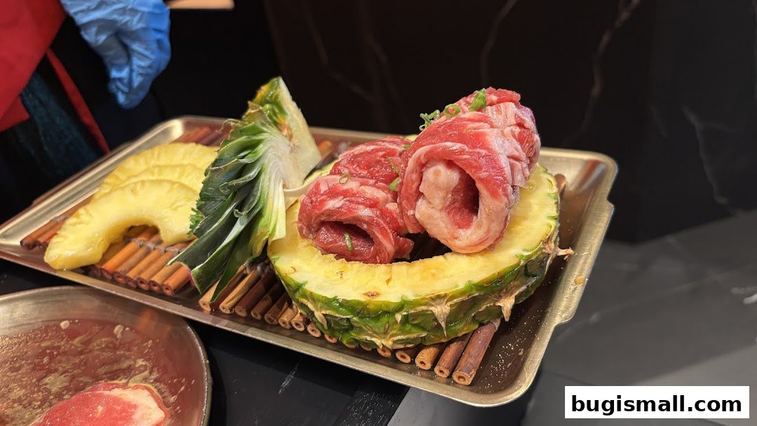 A tray of raw beef rolls presented with pineapple slices and pineapple core.
