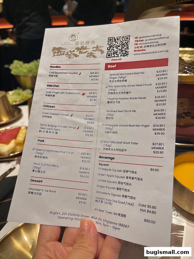 A person holds a menu from Xita Lao Tai Tai Singapore, showcasing various dishes and beverages.