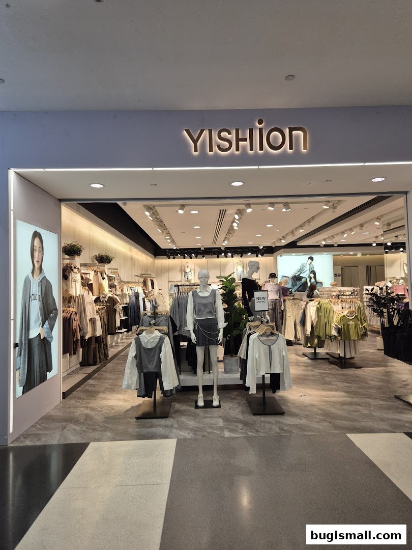 The entrance of a YISHION clothing store showcasing mannequins and apparel.