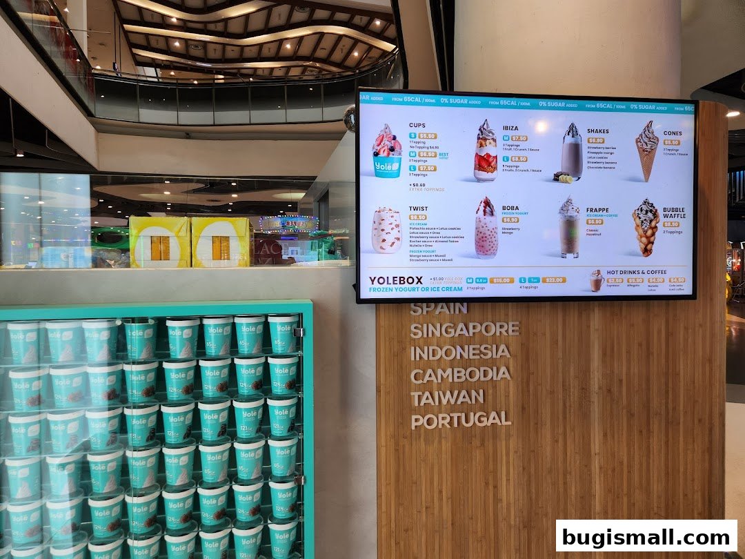 A digital menu board displaying various frozen yogurt and ice cream options from Yolé.